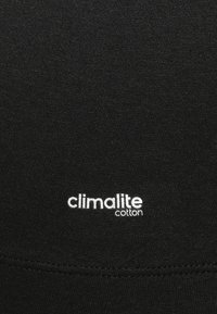 Tessuto di cotone nero caratterizzato da una superficie liscia con un logo "climalite cotton" stampato in bianco. Design minimalista, senza motivi o dettagli aggiuntivi.