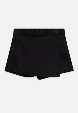 Skort noir style portefeuille avec fermeture latérale à bouton et broderie logo discrète près de l'ourlet sur fond uni.