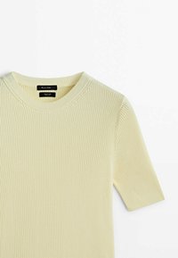 Ribbed, short-sleeve top in light yellow. Features a round neckline and subtle texture, made from soft fabric with a fitted shape.