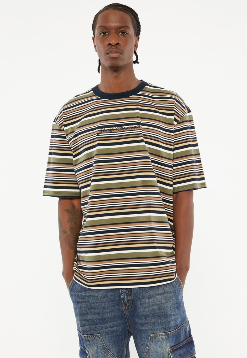 T-shirt à manches courtes rayé en vert olive, bleu marine et beige. Doté d'un col rond et de texte brodé à l'avant. Fabriqué en tissu lisse.