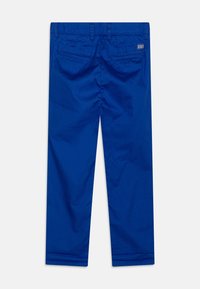 Pantaloni in cotone blu con una superficie liscia, dotati di una vita standard, tasche posteriori e una linea dritta.