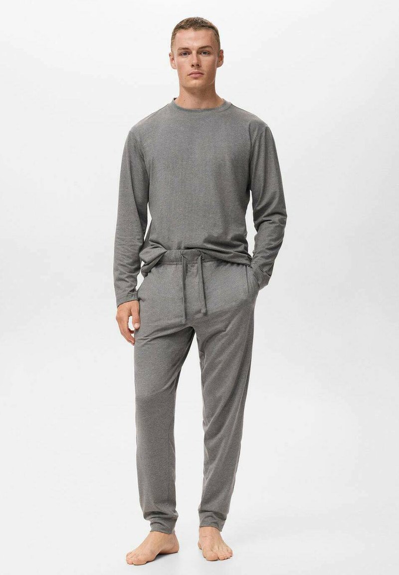Conjunto de ropa de casa gris que incluye una camiseta de manga larga y pantalones con cordón, hecho de una tela suave, con un corte relajado y puños acanalados.