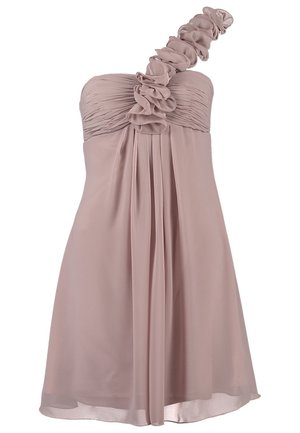 Donna che indossa un vestito monospalla di lunghezza al ginocchio color malva chiaro con dettagli a volant floreali e sandali beige con tacco alto, in piedi con le mani sui fianchi.