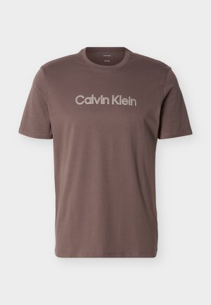 Brun T-shirt med korte ærmer og rund hals med "Calvin Klein" logo tekst centreret på brystet.