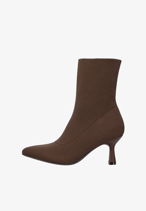 Stivale alla caviglia in tessuto marrone con punta affilata, design aderente e tacco sottile. Presenta una consistenza liscia e cuciture minime.