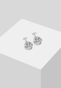 Cufflinks circolari in argento con una finitura testurizzata, caratterizzati da una parte superiore liscia e arrotondata e un perno dritto per la chiusura.