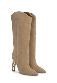 Bottes en suede beige jusqu'aux genoux avec des pointeurs et un talon en bloc orné de motifs géométriques. Texture lisse avec des accents latéraux sans couture.