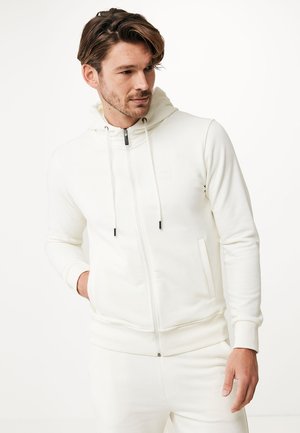 Witte zip-up hoodie van zacht materiaal, met een trekkoordkap, voorkruiszakken en contrasterende zwarte rits. 