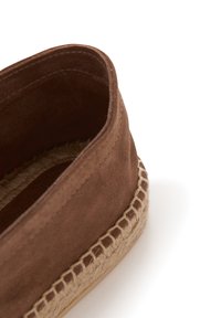 Ruskean mokka espadrillos, joissa on palmikkokudos juteepohja. Sisäosa on pehmeä, ja reuna on koristeltu ompelulla.