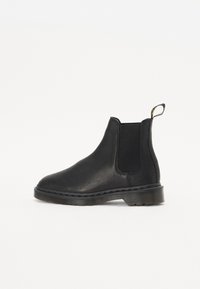 Zwarte leren Chelsea-boot met elastische zijpanelen, ronde neus en rubberen zool. Beschikt over een trekhaak aan de achterkant voor gemakkelijker aan- en uittrekken.