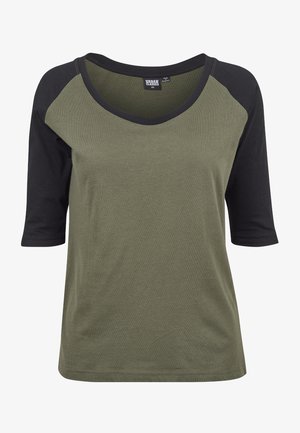 Olivroheline T-särk mustade raglan-sifritekidega. Omab laia ümmargust kaelust ja vabamat lõiget. Valmistatud pehmest, kergest kangast.
