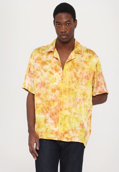 Camicia a maniche corte con bottoni in un motivo tie-dye giallo e arancione. Realizzata in tessuto morbido, presenta una vestibilità rilassata e un colletto a punta.
