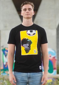 Zwarte t-shirt met een gele en groene silhouet van Afrika, een voetbal en de tekst: "2010 FIFA World Cup Zuid-Afrika."