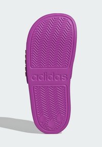 Fioletowa gumowa podeszwa zewnętrzna buta z wzorem jodełki, logo „adidas” oraz wytłoczonym numerem rozmiaru „12” po boku.