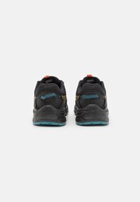 Des chaussures de sport noires avec une tige en tissu texturé, des accents orange, des détails bleus et une semelle rembourrée, vues de l'arrière.