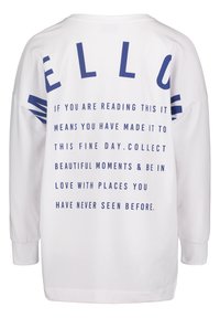 Chemise blanche à manches longues avec un grand texte bleu « MELLOW » et un message inspirant sur l'appréciation des beaux moments et des nouveaux endroits au dos.