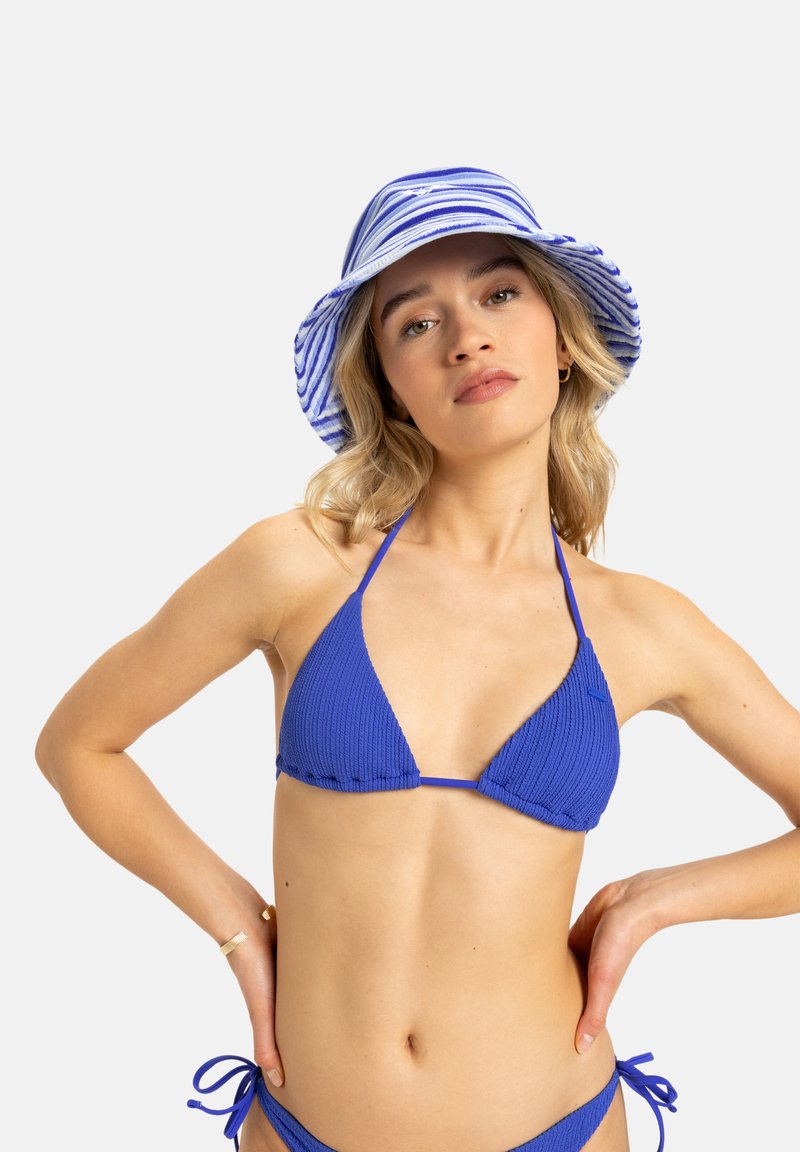 Blå ribbet bikini sett med trekantet topp med tynne stropper og matchende bunn med knytte sider. Kombinert med en blå og hvitstribet bøttehatt.
