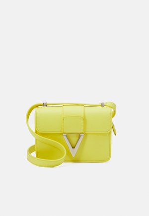 Bolso cruzado de cuero amarillo con cierre de solapa, que presenta un acento plateado en forma de V y una correa ajustable. Textura suave y diseño compacto.