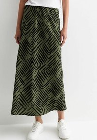 Jupe maxi vert olive avec un motif abstrait en zigzag noir, fabriquée en tissu doux, dotée d'une taille élastique et d'une fente sur le côté.