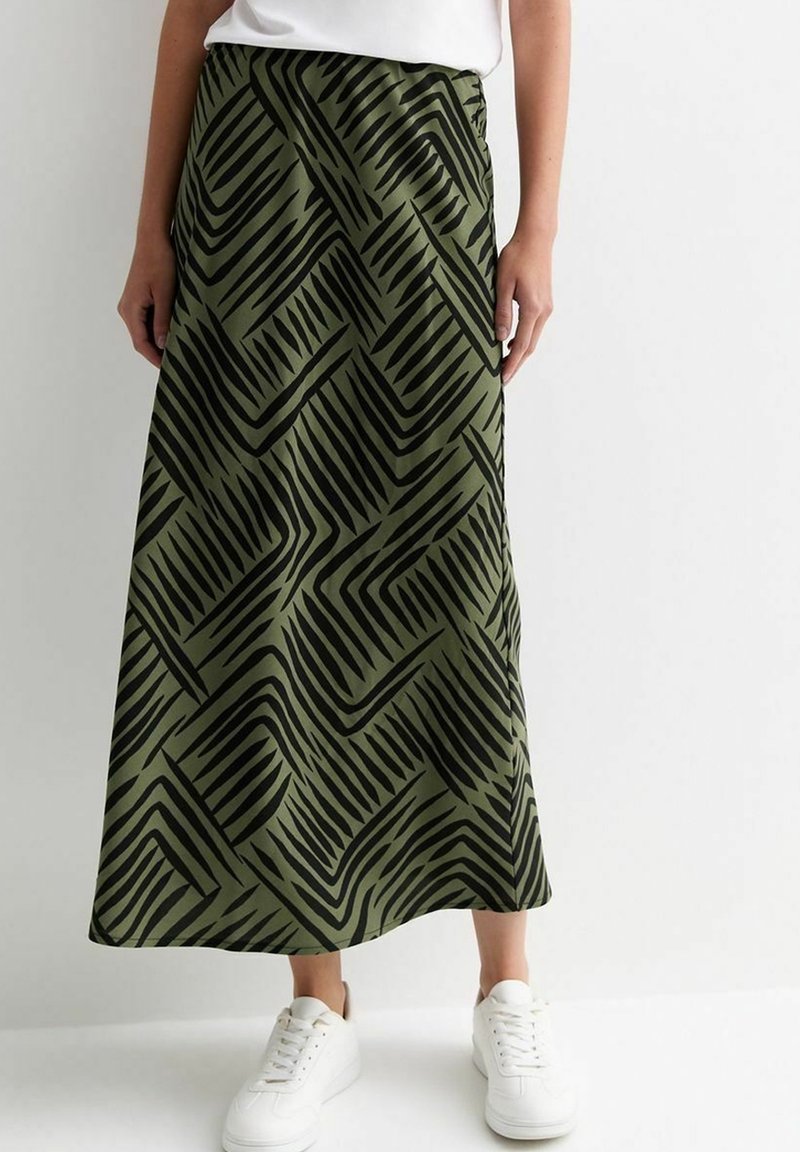 Jupe maxi vert olive avec un motif abstrait en zigzag noir, fabriquée en tissu doux, dotée d'une taille élastique et d'une fente sur le côté.