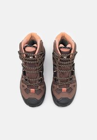 Brown hiking boots with pink accents, featuring textured fabric, durable rubber soles, and braided laces for secure fit.