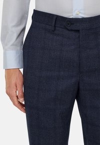 Jūras zila piegriezuma bikses ar subtilu šaha rakstu, ar plakanu priekšpusi, jostu cilpiņām un vienu pogu aizdari.