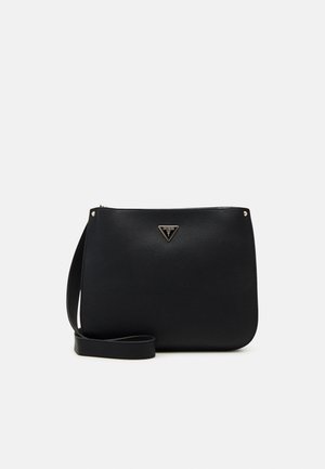 Schwarze Leder-Umhängetasche mit dünnem Riemen und kleinem dreieckigem Guess-Logo auf der Vorderseite, vor einem einfarbigen hellen Hintergrund.