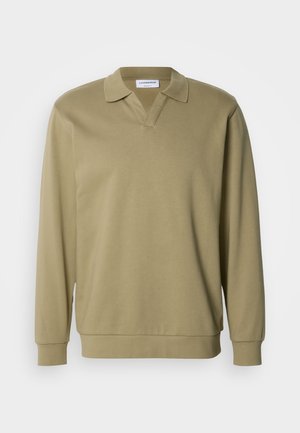 Khaki hosszú ujjú galléros póló V-nyakkivágással, puha anyagból. Klasszikus gallérral és bordás mandzsettákkal rendelkezik, lazább szabással.