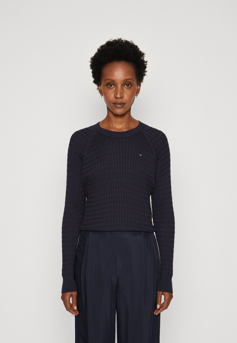 Maglione lavorato a maglia blu navy con un motivo testurizzato, scollo rotondo e maniche lunghe. Presenta polsini a coste e un piccolo dettaglio con logo.