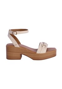 Sandalias de plataforma beige con tacón cuadrado, correas de cuero, una correa ajustable en el tobillo y una hebilla decorativa en la parte frontal.