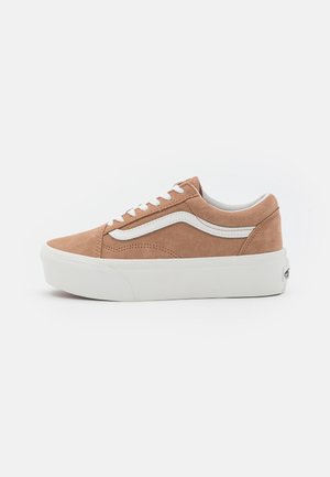 Lysebrun lavtop sneakers i ruskind med hvid sideliste, hvide snørebånd og tyk hvid gummisål mod ensfarvet baggrund.