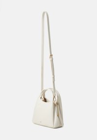 Sac à main synthétique blanc avec un corps arrondi, une bandoulière réglable, des accessoires en or et une poche zippée sur le côté pour une fonctionnalité supplémentaire.