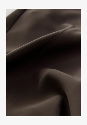 Ruskea kangas, jossa on sileä pinta, hienovaraisia laskoksia ja saumoja, esittelee mattapintaisen lopputuloksen ilman erottuvia kuvioita tai yksityiskohtia.