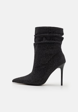 Schwarze Knöchelstiefel aus strukturiertem Stoff mit lässigem Design, spitz zulaufender Zehenpartie und glänzendem Stiletto-Absatz. Mit schimmernden Akzenten.