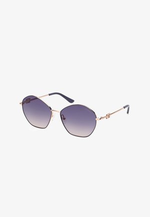 Occhiali da sole esagonali con lenti viola sfumate, montatura in metallo dorato e aste in acetato blu con dettaglio del logo.