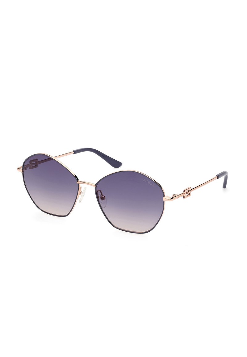 Occhiali da sole esagonali con lenti viola sfumate, montatura in metallo dorato e aste in acetato blu con dettaglio del logo.