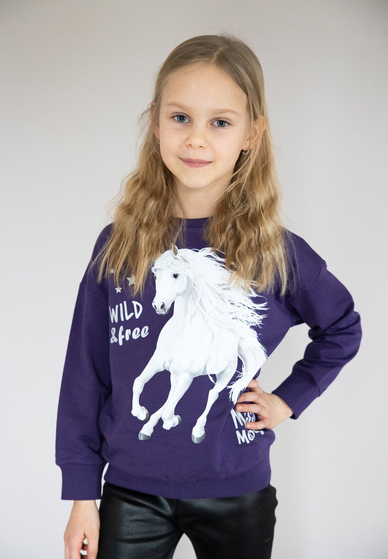 Felpa viola con un'immagine di un cavallo al galoppo in bianco e la scritta "WILD & free". Tessuto morbido, maniche lunghe e polsini a coste all'orlo.
