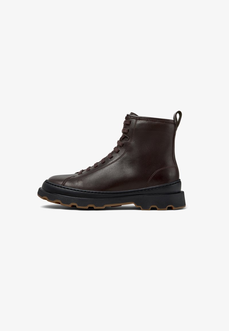 Brown leather ankle boot with a round toe, lace-up design, and textured black sole featuring raised rubber studs for traction.