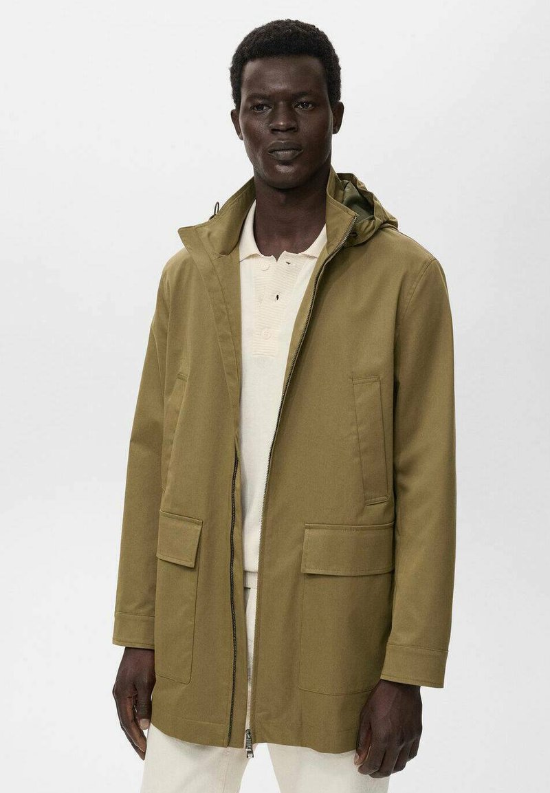 Chaqueta verde oliva de longitud media con capucha, cremallera en la parte delantera y dos grandes bolsillos frontales; textura suave y diseño minimalista.