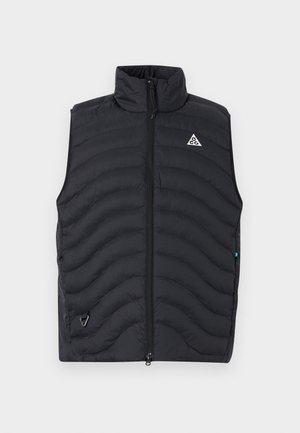 Veste sans manches matelassée noire avec fermeture éclair à l'avant, col montant et petit logo triangulaire sur la poitrine gauche.