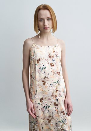 Silkekjole med blomstret broderi, der har en lys cremefarvet bund, tynde stropper og et flydende design med flerfarvede planter og blomster.