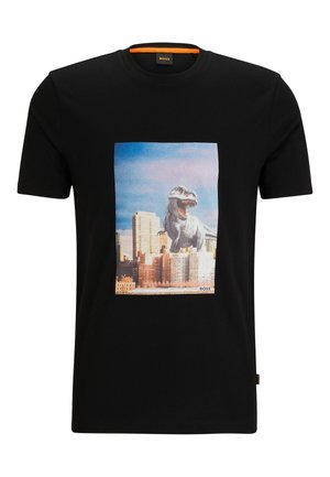 T-shirt noir à manches courtes avec un graphisme d'un T-Rex rugissant dominant les bâtiments de la ville sous un ciel bleu.