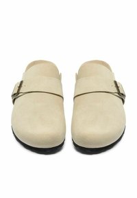 Zoccoli in suede beige con una ampia fascia e una fibbia argentata, dalla punta tonda, su una suola nera dalla texture esclusiva.