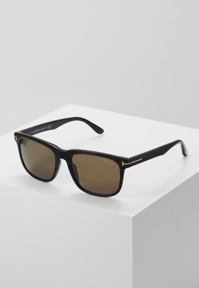 Black acetate sunglasses with brown lenses. Features gold-tone accents on the arms. Square shape with a smooth texture and minimal branding.