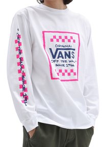 Bílý dlouhý rukáv tričko s výrazným růžovým a modrým logem Vans, kostkovanými akcenty na rukávech a volným střihem.
