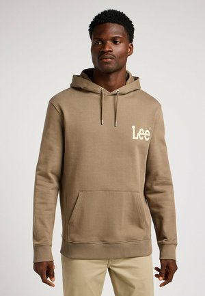 Brązowa bluza z kapturem, z kieszenią na przodzie, sznurkiem ściągającym, ściągaczami przy rękawach oraz kremowym logo "Lee" po lewej stronie klatki piersiowej.