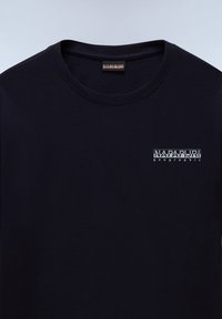 T-shirt en coton bleu marine avec un col rond, arborant un petit logo blanc et du texte sur la zone supérieure gauche de la poitrine. Texture lisse, manches courtes.