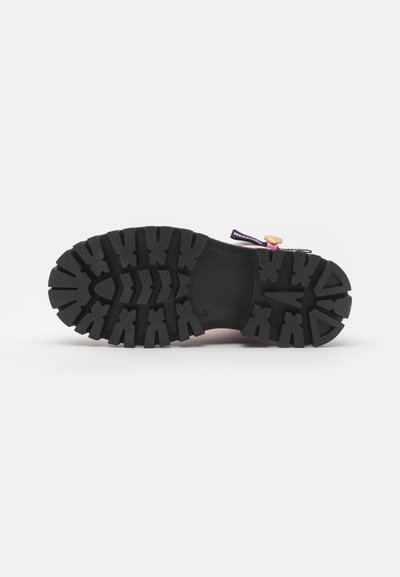 Suela de zapato de goma negra con un patrón de tracción resistente. Presenta una parte superior rosa y un botón decorativo amarillo con un cordón morado. En general, un diseño robusto.