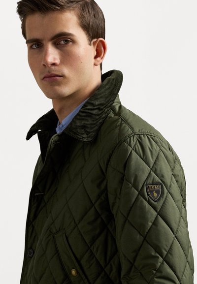 Quilted green jacket with a corduroy collar, side pocket, and a navy badge featuring "POLO" on the left chest area.