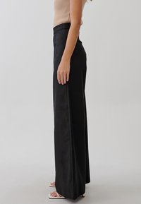 TUSSAH Kalhoty - black